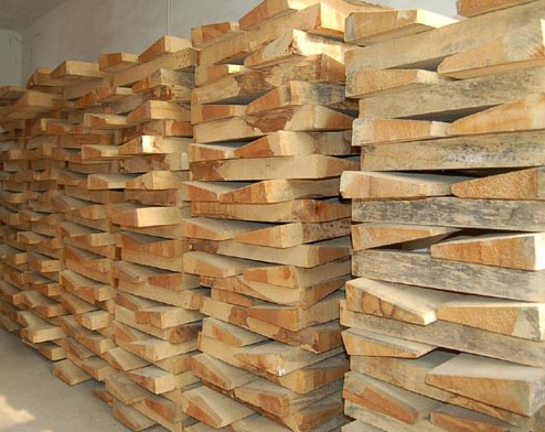 Rough-cut tonewood billets stacked on racks.